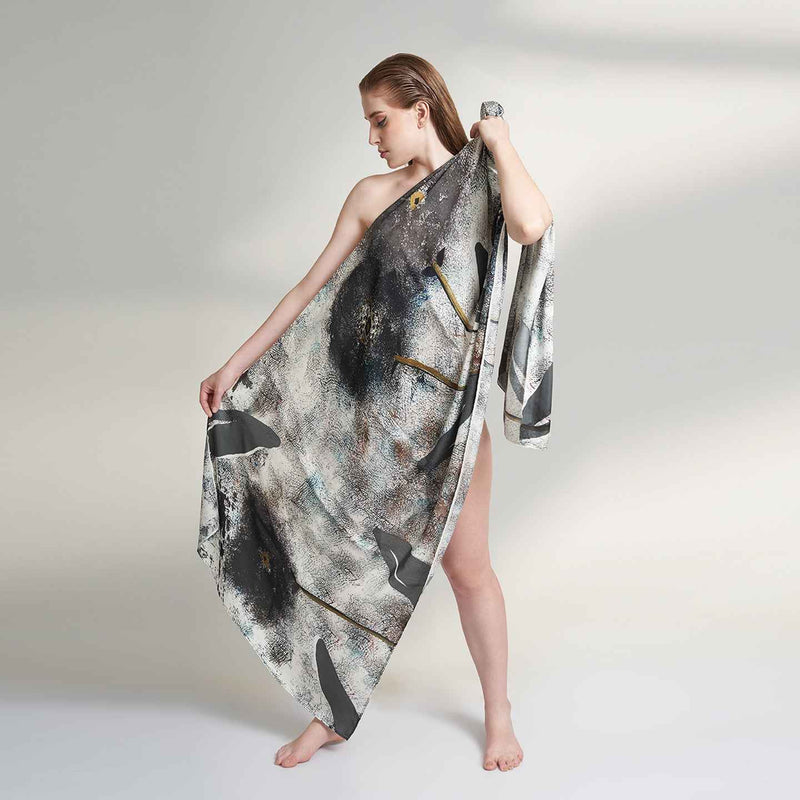 Model wearing the grey and black abstract print scarf as a one-shoulder wrap dress