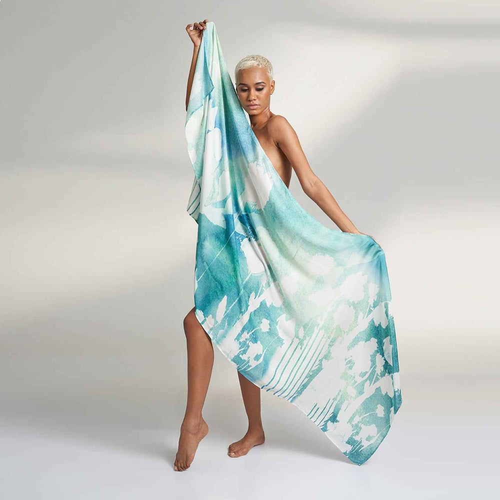 Model holding out the teal green watercolor tie-dye print scarf