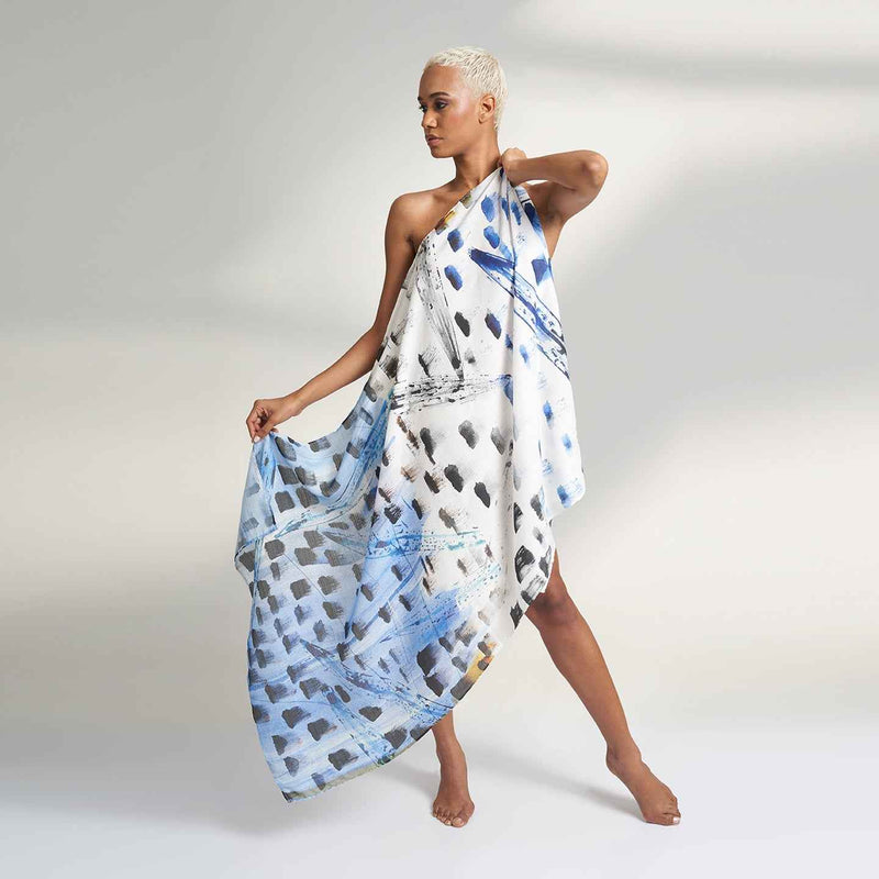 Model wearing the blue and navy paint-dab print scarf as a one-shoulder wrap dress