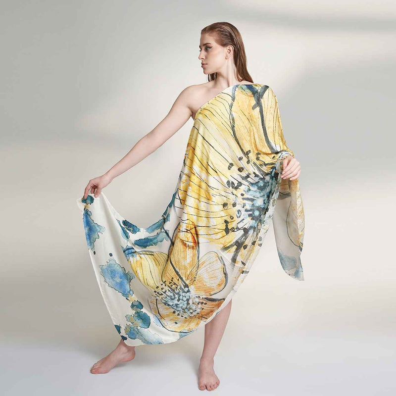 Model wearing the yellow and blue floral watercolor print scarf as a one-shoulder wrap dress