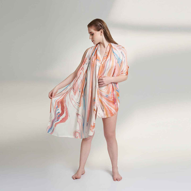 Model wearing the coral marbled swirl print scarf as a wrap dress