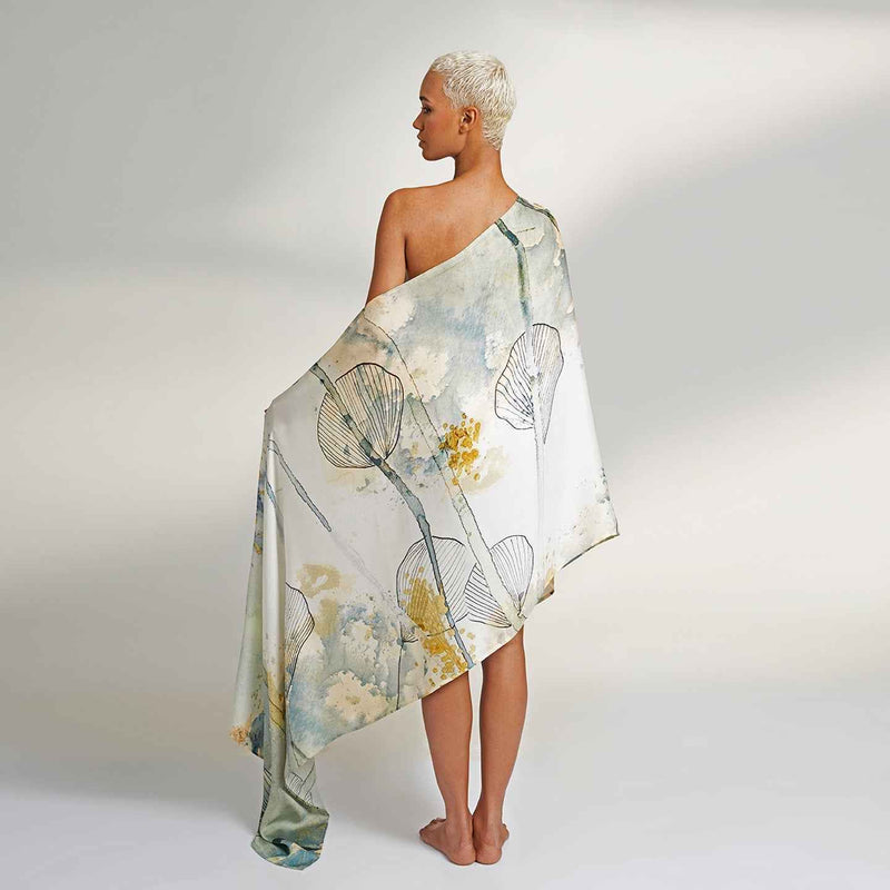 Model draped in the white and yellow watercolor floral print scarf, one-shoulder style