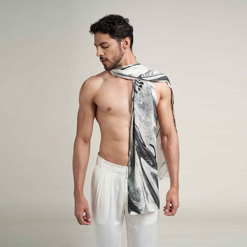 Front view of a man wearing the grey and black marbled print scarf with white trousers
