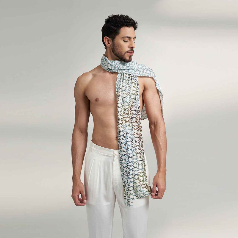 Front view of a man wearing the blue and white geometric floral print scarf, styled with white trousers