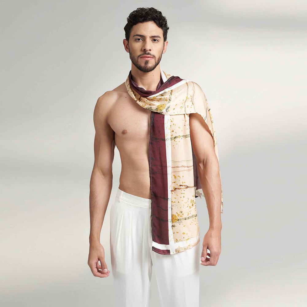 Front view of a man wearing the wine and gold branch print scarf with white trousers