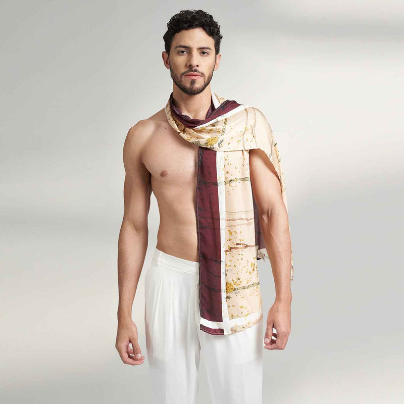 Front view of a man wearing the wine and gold branch print scarf with white trousers
