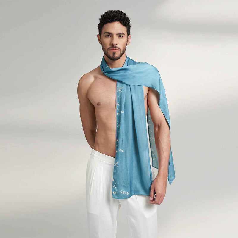 Front view of a man wearing the solid teal scarf with a dotted border, styled with white trousers