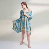 Front view of the model wearing the teal blue and gold branch print scarf as a wrap