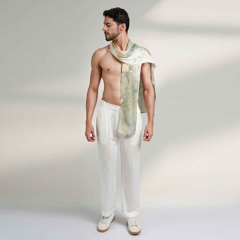 Front view of a man wearing the grey and gold watercolor floral print scarf with white trousers