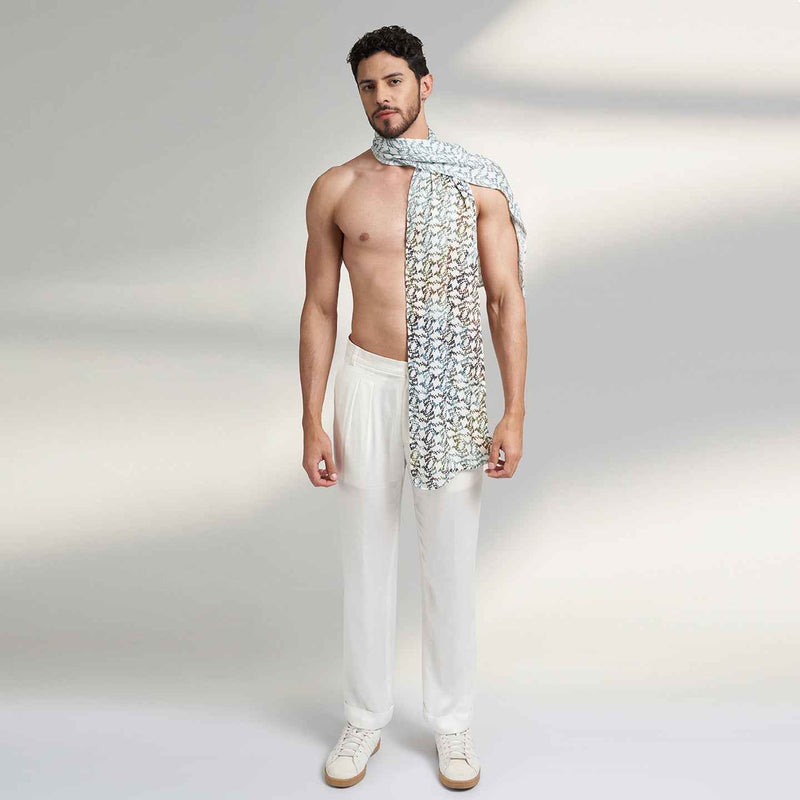 Side view of a man wearing the blue and white geometric floral print scarf with white trousers