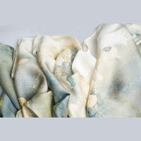 Close-up of the grey and gold watercolor floral print scarf fabric, folded