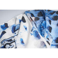 Close-up of the blue and navy paint-dab print scarf fabric, gathered