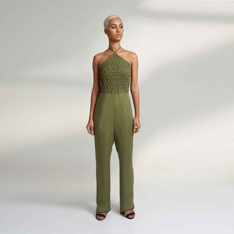 Angled front view of the olive green jumpsuit with a smocked halter neckline