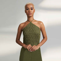 Close-up front view of the olive green jumpsuit showing the smocked bodice detail
