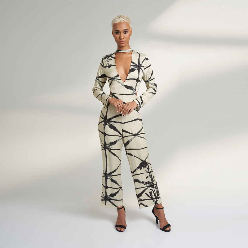 Front view of the cream and black abstract print jumpsuit with a plunging keyhole neckline
