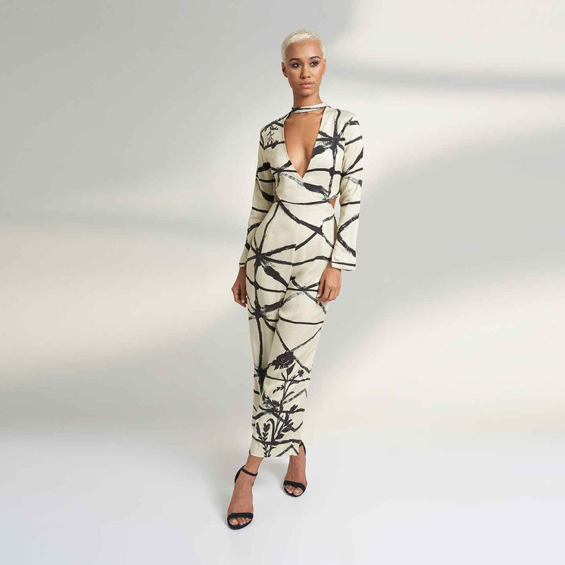 Angled front view of the cream and black print jumpsuit