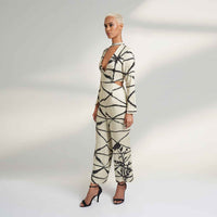 Side view of the cream and black abstract print jumpsuit showing the waist cutout