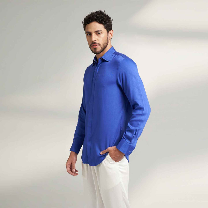 Side view of the solid royal blue shirt styled with white trousers