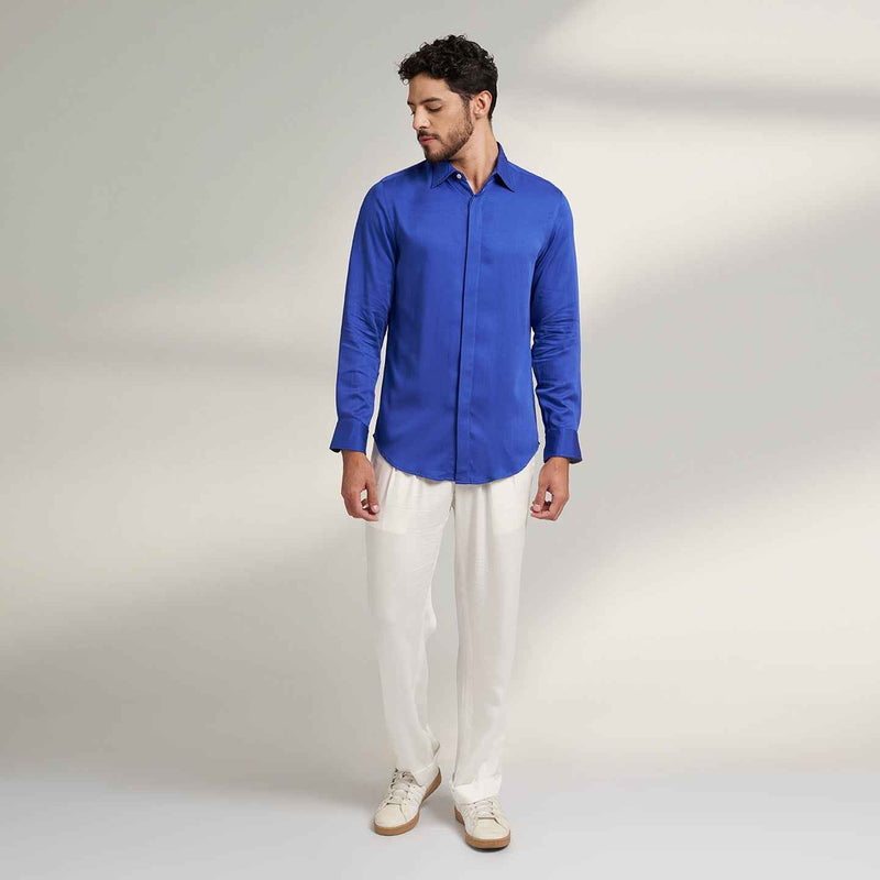 Front view of the solid royal blue shirt and white trousers