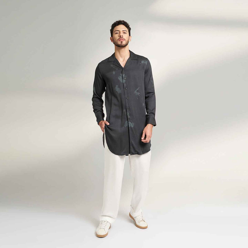 Front view of the longline black and grey tonal print shirt and white trousers