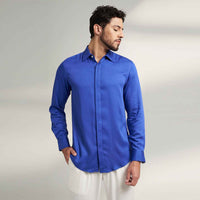 Angled front view of the solid royal blue shirt with white trousers