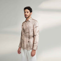 Side view of the blush pink speckled print shirt with white trousers