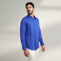 Side profile view of the solid royal blue shirt with white trousers