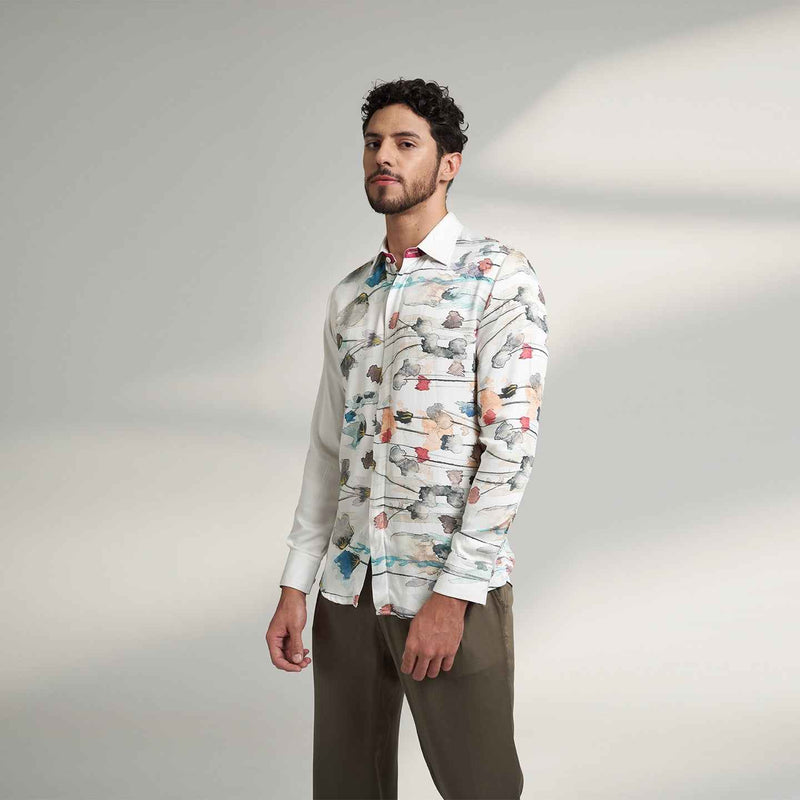 Angled front view of the white floral print shirt styled with olive trousers