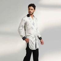 Angled front view of the longline black and white tie-dye print shirt with contrast black collar, styled with black trousers