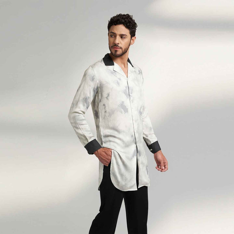 Angled front view of the longline black and white tie-dye print shirt with contrast black collar, styled with black trousers