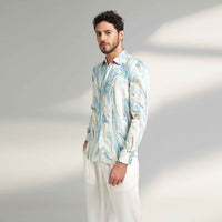 Angled front view of the blue and white marbled print shirt with white trousers