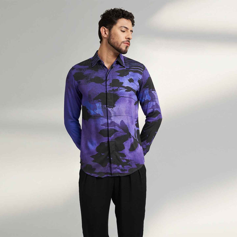 Angled front view of the purple and black abstract floral print shirt styled with black trousers