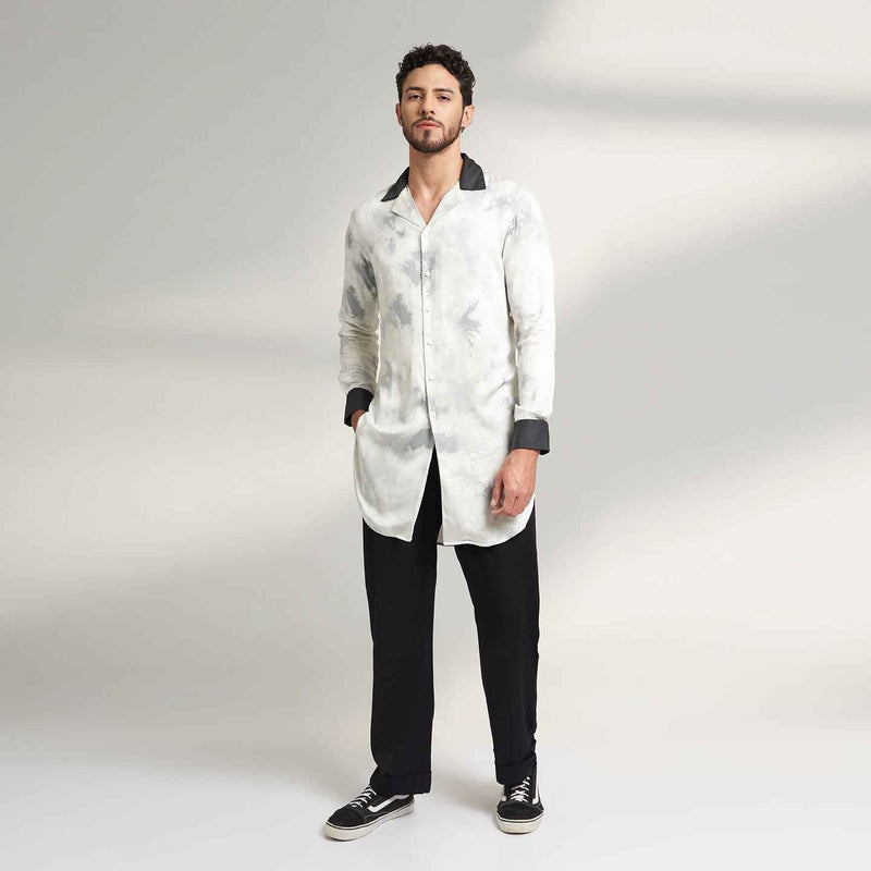 Front view of the longline black and white tie-dye print shirt and black trousers