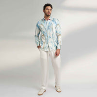 Front view of the blue and white marbled print shirt and white trousers