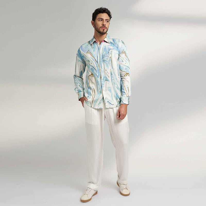 Front view of the blue and white marbled print shirt and white trousers
