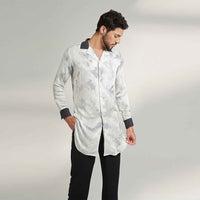 Side view of the longline tie-dye print shirt with contrast black collar and black trousers