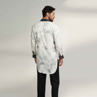 Back view of the longline black and white tie-dye print shirt with black trousers