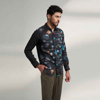 Side view of the black floral print shirt with olive trousers
