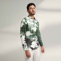 Side view of the sea green and white abstract print shirt with white trousers