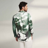 Back view of the sea green and white abstract print shirt with white trousers
