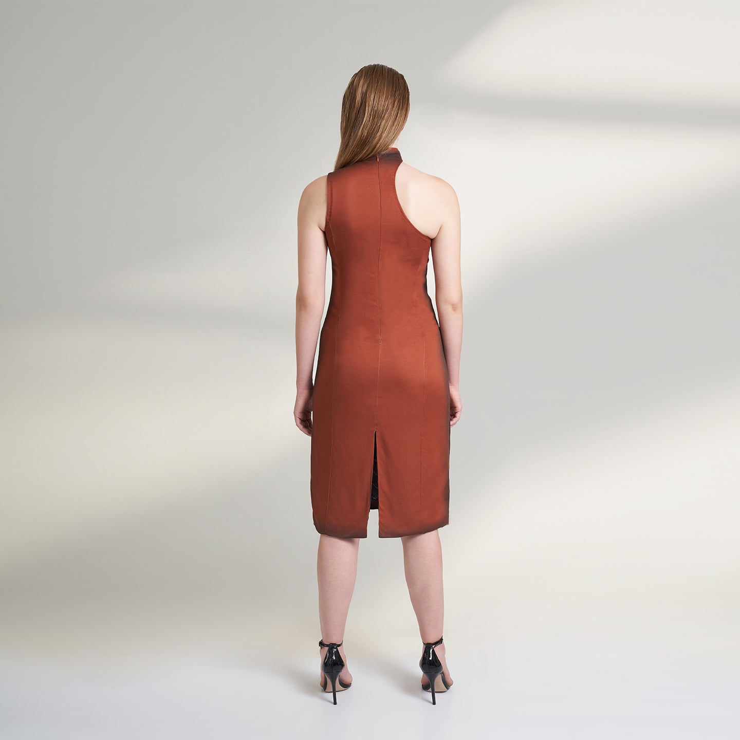 A global medium size model wearing a maroon wine dress with an asymmetrical neckline and a cut-work on left shoulder highlighted with ombre edges all over; crafted in organic lotus stem fabric.