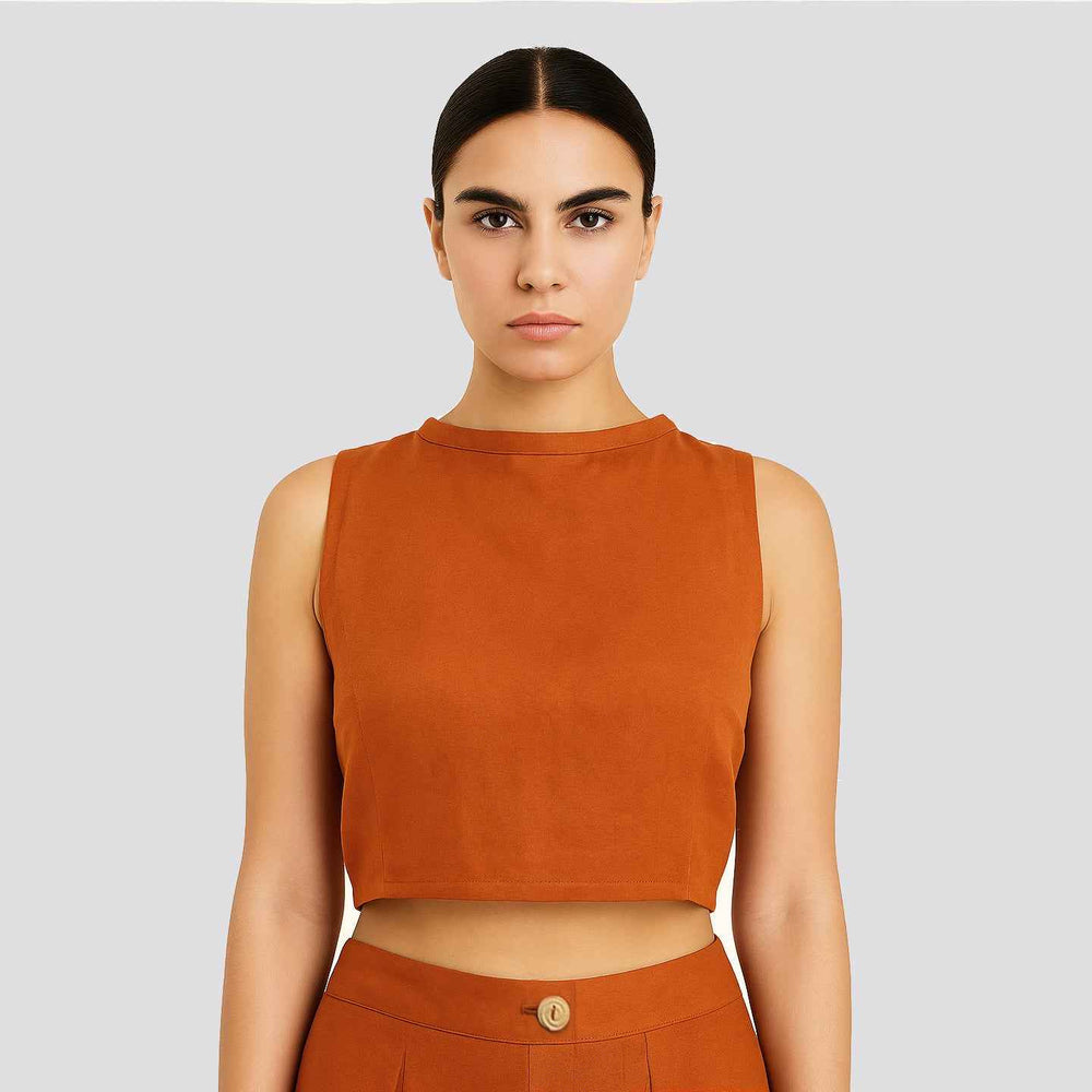 Close-up front view of the burnt orange Lotus Stem Silk crop top with a high, sleeveless neckline