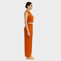 Side profile view of the burnt orange crop top and wide-leg trousers