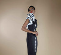 Close-up side view of the black midi dress highlighting the rosette shoulder detail