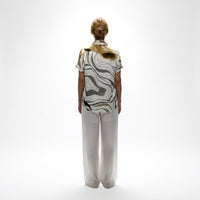 Back view of the abstract print shirt and white wide-leg trousers