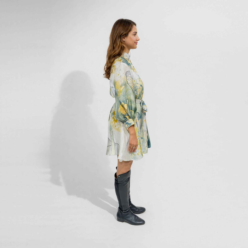 Side profile view of the belted botanical print short dress with knee-high black boots