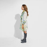 Side view of the botanical print short dress showing the tied waist belt and sleeve detail