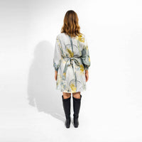 Back view of the multicolor botanical print short dress with knee-high black boots